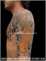 Tatuaje de un carpa bajando por el brazo por encima del agua