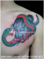 Tatuaje de una serpiente rodeando la cabeza acuchillada de un samurai