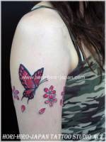 Tatuaje de un brazalete de flores con una mariposa