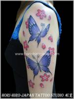 Tatuaje de mariposas y flores en el brazo