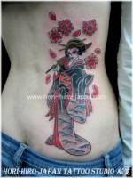 Tatuaje de una geisha con flores y pétalos