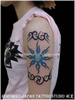 Tatuaje de sol y tribales en el brazo