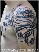 Tattoo de fénix tribal con flores en el brazo y pecho