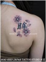 Tatuaje para chica de flores y petalos con kanji