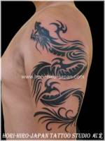 Tatuaje de dragon tribal en el brazo.