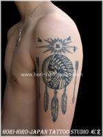 Tattoo de cabeza de indio con plumas y flechas en el brazo