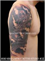 Tatuaje de un dragon en el brazo con una bola con kanji dentro