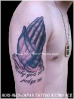 Tatuaje de manos rezando en el brazo