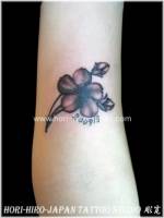 Tatuaje de pequeña flor, con el año