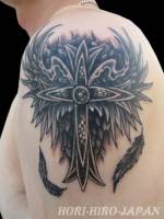 Tatuaje de cruz con alas en el brazo