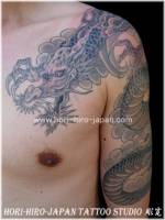 Tatuaje de un dragón entre nubes