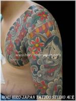 Tatuaje del demonio japonés entre flores y nubes