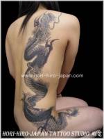 Tatuaje de un dragon que va de la pierna al cuello de una mujer