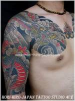 Tatuaje de un dragón típico japonés en brazo y pecho