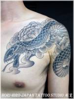 Tatuaje japonés de una serpiente entre flores de loto