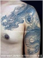 Tatuaje de un dragon que va por el brazo y pecho