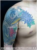 Tatuaje de una carpa con flores en el brazo y hombro