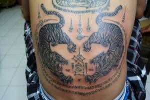 Tatuaje de unos tigres Sak Yant en la espalda