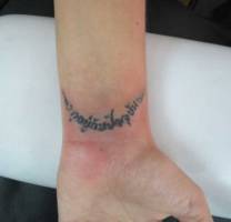 Tatuaje de un mantra en el brazo