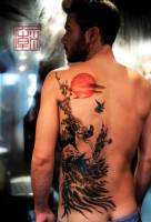 Tatuaje de un paisaje dibujado a pincel en la espalda