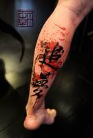 Tatuaje de unos kanjis con manchas de pintura detrás