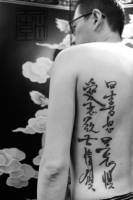 Tatuaje de kanjis en la espalda de un hombre