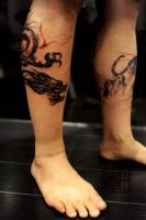 Tatuaje de un dragón dibujado a pincel en la pierna