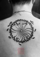 Tatuaje de un circulo con unos símbolos en sanscrito