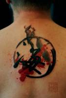 Tatuaje de un kanji en la espalda, rodeado de un circulo, hecho con estilo pincel