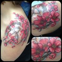Tatuaje de unas ramas con flores en la espalda