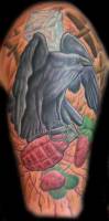 Tatuaje de un cuervo agarrando una granada