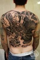 Tatuaje de un dragón con sus garras. Tatuaje en la espalda
