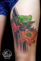 Tatuaje de una rana encima de una flor que sale del agua