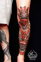 Tatuaje de mascaras maoris en la pierna