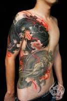 Tatuaje espectacular de dragón en brazo tronco