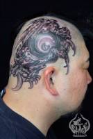 Tatuaje de un ojo y unas garras en la cabeza