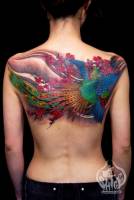 Tatuaje de un ave fénix volando entre flores