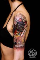 Tatuaje de un gato y una carpa en el brazo de una mujer