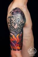 Tatuaje de un ogro japonés en el brazo, encima de una flor con llamas