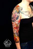 Tatuaje de carpas y flores a color en el brazo