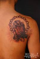Tatuaje de unas manos rezando, con varias telarañas y una araña