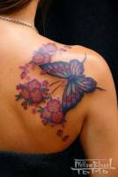 Tatuaje de mariposas y flores en la espalda.