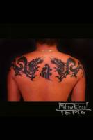 Tatuaje de dragones sanefa en la espalda, con letra en medio