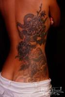 Tatuaje de chica, serpientes, flores y monos en media espalda y culo.