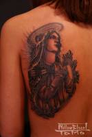 Tatuaje de la virgen en la espalda.