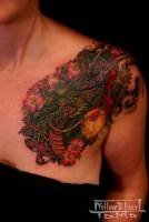 Tatuaje de un dragón con muchas flores en una mujer