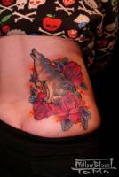 Tatuaje de lobo aullando entre rosas