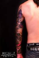 Tatuaje de calaveras y libélulas en el brazo