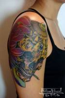 Tattoo de calavera y flores en el brazo