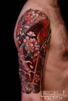 Tattoo de Koi en el brazo entre flores